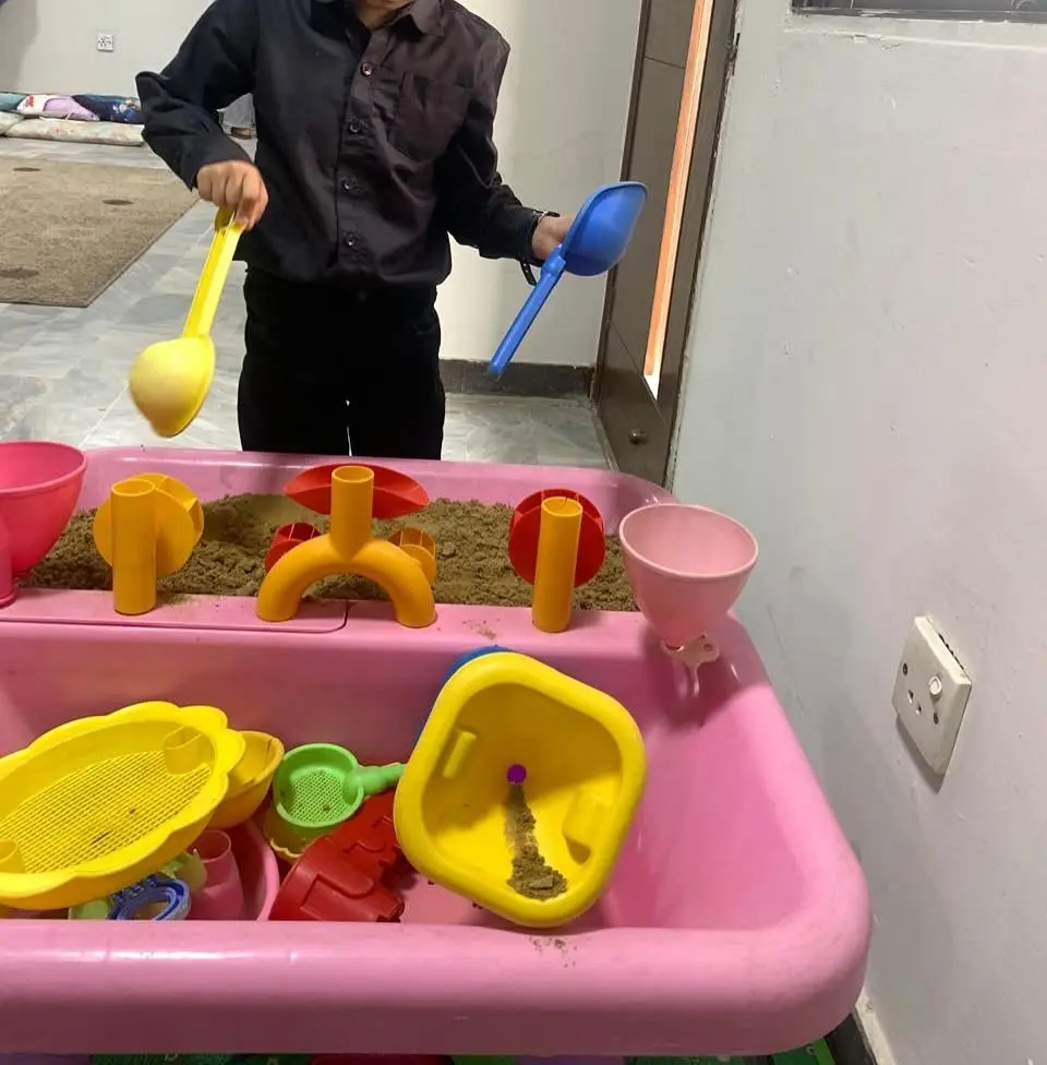 A younger student engaged in hands-on sensory play activity